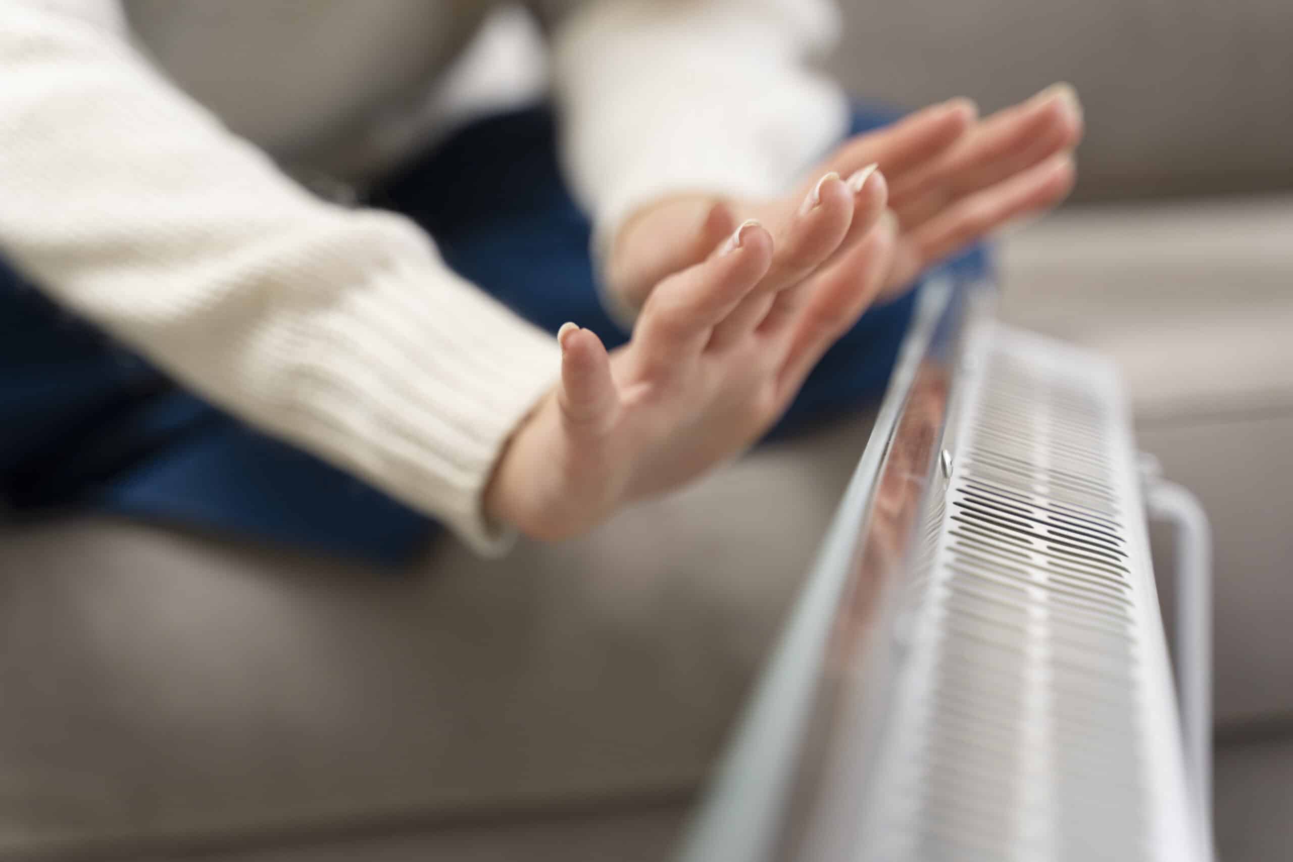 mains radiateur mains proches d'un radiateur pour vérifier la chaleur qui s'en dégage